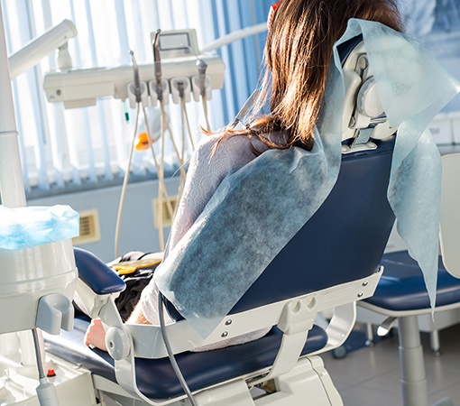 Patient sitting on dental chair, waiting for her dentist. Stomatology medicine, dental care, prevention, health concept. pokaz koron zębowych